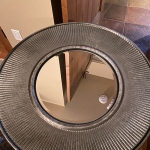 Round galvanized framed mirror.